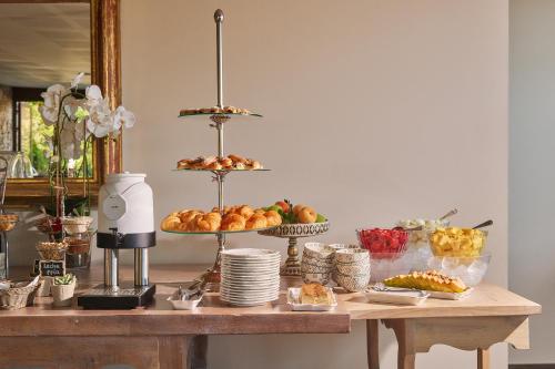 a table with several tiers of bread and pastries at Hotel Boutique Cigarral de las Mercedes in Toledo