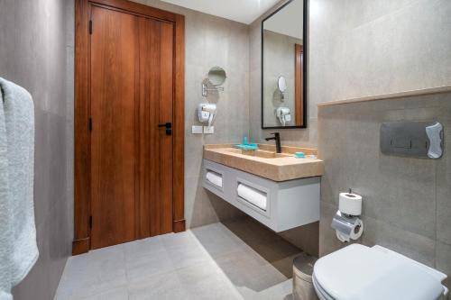 ein Badezimmer mit einem Waschbecken, einem WC und einem Spiegel in der Unterkunft Al Masa Hotel El Sokhna in Ain Suchna