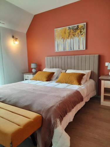 une chambre avec un grand lit aux murs orange dans l'établissement Appartement 50m du centre historique, à Sarlat-la-Canéda