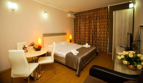 a hotel room with a bed and a table at Royal Apartments in Batumi