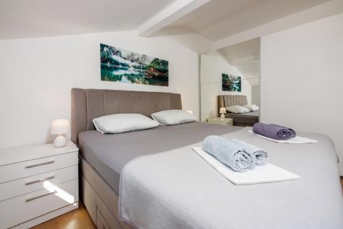 a bedroom with two beds with towels on them at Apartment Davor in Dramalj