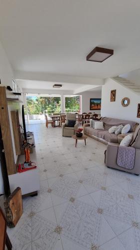 a large living room with couches and a table at Casa da Barbie na praia de Carapibus PB in Conde