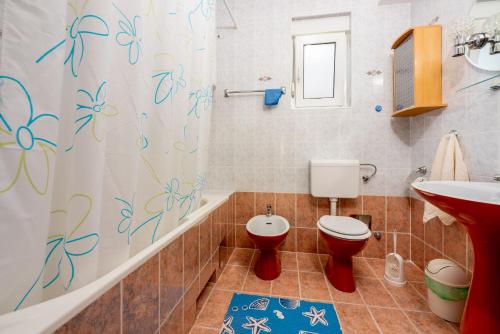 a bathroom with a toilet and a sink and a shower curtain at Apartments Antonio in Crikvenica