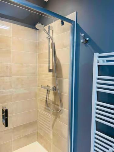 une douche avec une porte vitrée dans une salle de bain dans l'établissement Appartement 50m du centre historique, à Sarlat-la-Canéda