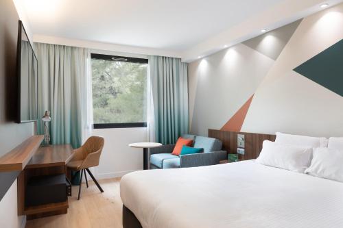 a hotel room with a bed and a desk at Holiday Inn - Marseille Airport by IHG in Vitrolles
