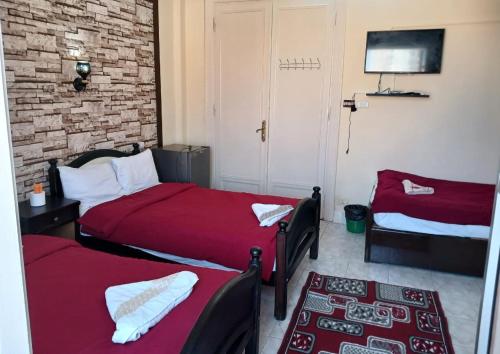 1 dormitorio con 2 camas y pared de ladrillo en New Palace Hotel, en El Cairo