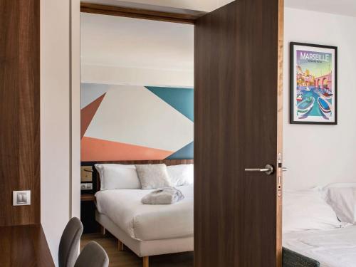 a bedroom with a bed and a door leading to a bedroom at Holiday Inn - Marseille Airport by IHG in Vitrolles