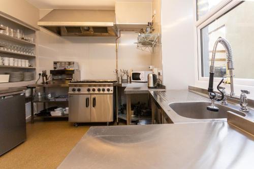 a kitchen with a stainless steel sink and a stove at Howgills House Hotel in Sedbergh