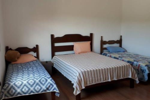 カショエイラ・ド・カンポにあるSítio da Serra em Ouro Preto MGのベッド2台が隣同士に設置された部屋です。