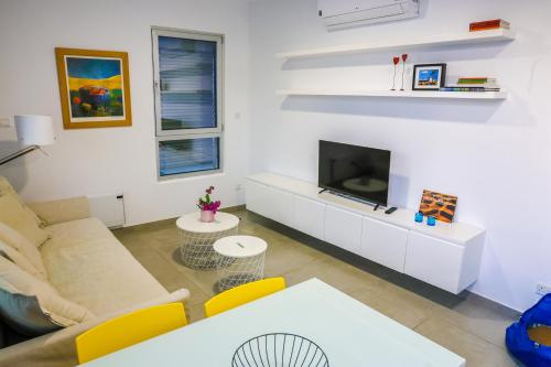 a living room with a couch and a tv at Luxury Stay in İncirli