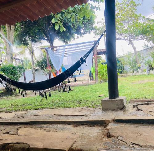 a hammock hanging from a pole in a park at SITIO RECANTO DOS PASSAROS in Itacaré