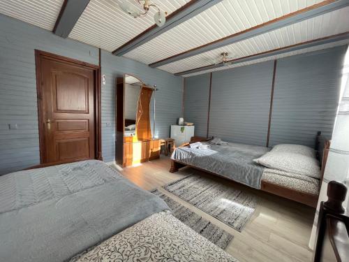 a bedroom with two beds and a wooden floor at Sadyba u Halyny Sunrise in Bukovel
