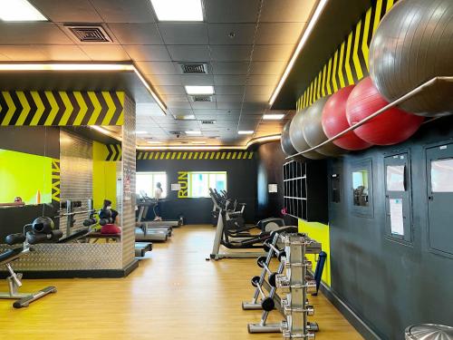 a gym with treadmills and exercise equipment on the walls at SKY High Stays in Dubai