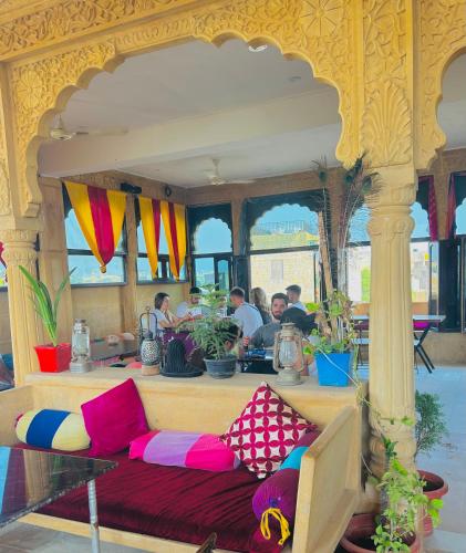 a room with a couch with colorful pillows on it at Hotel Pol Haveli Jaisalmer in Jaisalmer