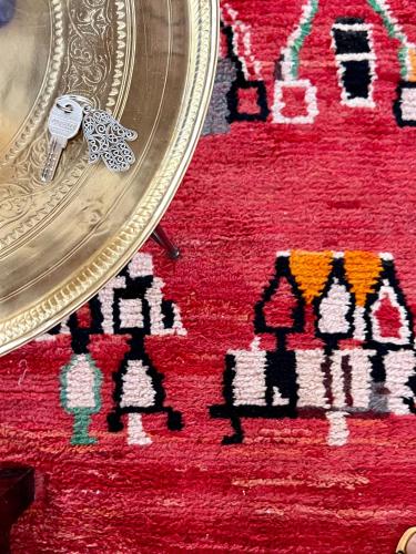 a key on top of a red rug with a mirror at Riad Tizwa Marrakech in Marrakech