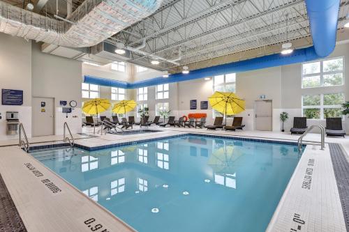uma piscina num hospital com cadeiras e um quarto grande em Microtel Inn & Suites by Wyndham Kanata Ottawa West em Kanata