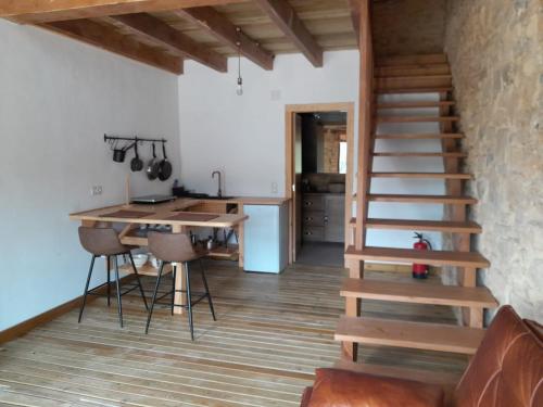 a room with a staircase and a kitchen with a table at Loft Estación Quintana in Gijón