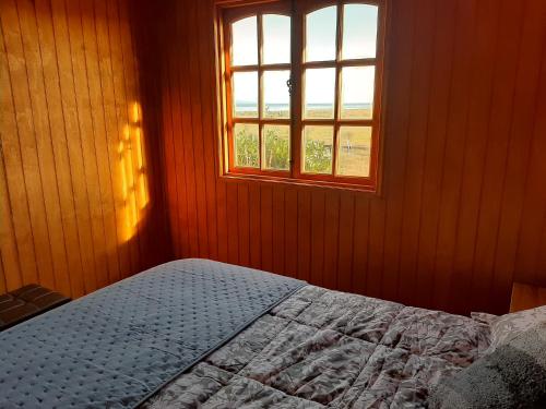 a bedroom with a bed and a window at Cabañas de Campo MARBAJA in Puerto Montt