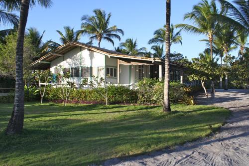 uma casa na praia com palmeiras em Fazenda Pranchão em Prado