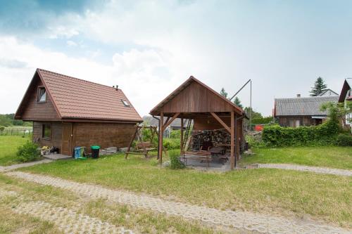 a house with a gazebo in a field at Happy Bison - A 5 Bedroom House With A Garden in Białowieża