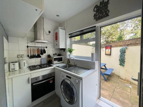 a kitchen with a washing machine and a window at Studio in Camden, King's Cross in London