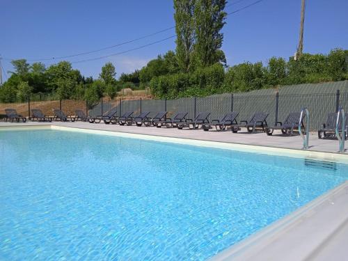 a swimming pool with chairs and a fence at Holiday Home Le Domaine du Lambon-2 by Interhome in Prailles