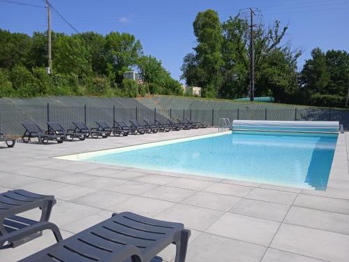 a swimming pool with lounge chairs next to a fence at Holiday Home Le Domaine du Lambon-2 by Interhome in Prailles