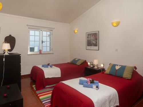 a bedroom with two beds with red and white sheets at Villa Mar de Prata by Interhome in Sesimbra