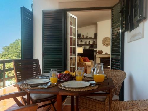 a table with plates of fruit and glasses of orange juice at Villa Mar de Prata by Interhome in Sesimbra