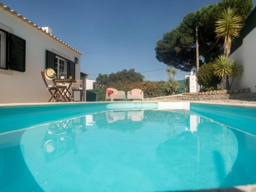 a swimming pool in front of a house at Villa Mar de Prata by Interhome in Sesimbra
