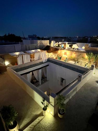 a white building with lights on the roof at night at Riad Tizwa Marrakech in Marrakech
