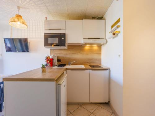 une cuisine avec des armoires blanches et un comptoir dans l'établissement Studio Port La Roquille-1 by Interhome, au Cap d'Agde