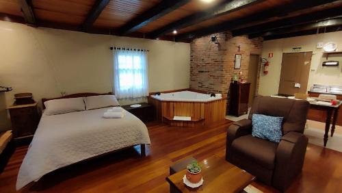 ein Schlafzimmer mit einem Bett und einer Badewanne in einem Zimmer in der Unterkunft Cabana Casa Enxaimel in Picada Cafe