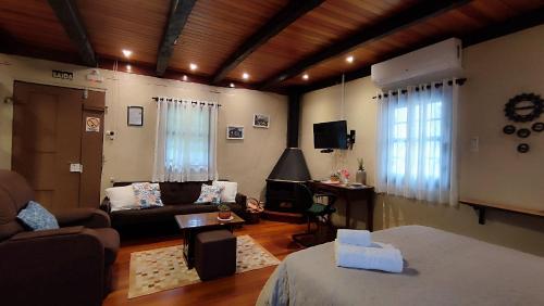 a living room with a couch and a table and a living room at Cabana Casa Enxaimel in Picada Cafe