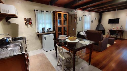 a kitchen and living room with a table and a couch at Cabana Casa Enxaimel in Picada Cafe