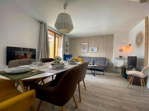 a dining room and living room with a table and chairs at Chalet de 3 chambres a Le Devoluy a 200 m des pistes avec piscine partagee sauna et terrasse in Le Dévoluy