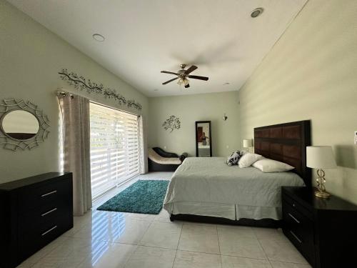 - une chambre avec un lit et un ventilateur de plafond dans l'établissement Casa Sasha's Mini Palace, à Cancún