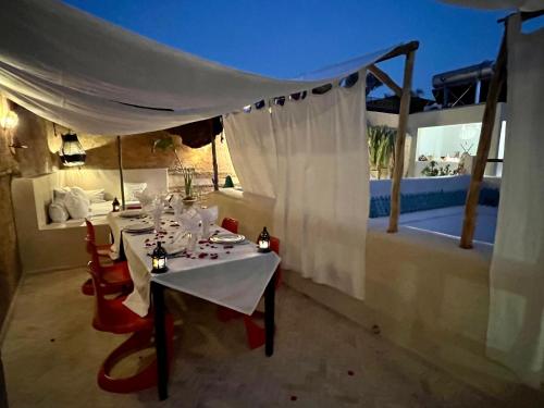a dining room with a table and chairs on a patio at Riad Tizwa Marrakech in Marrakech