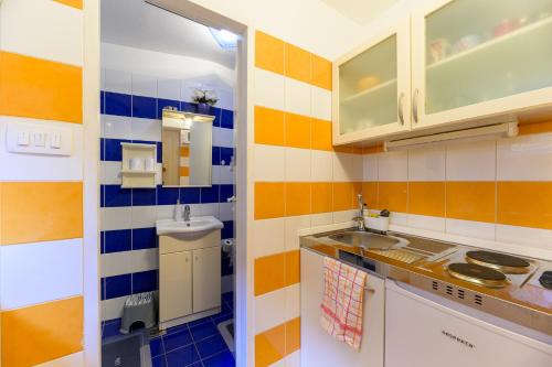 a small kitchen with colorful tiles on the wall at Main Square Studio Mare in Zagreb