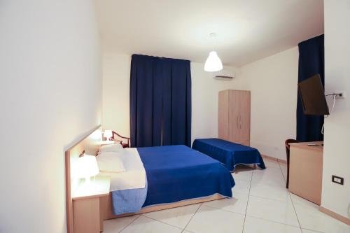 a bedroom with a blue bed and blue curtains at max hotel e restaurant in Pontecagnano