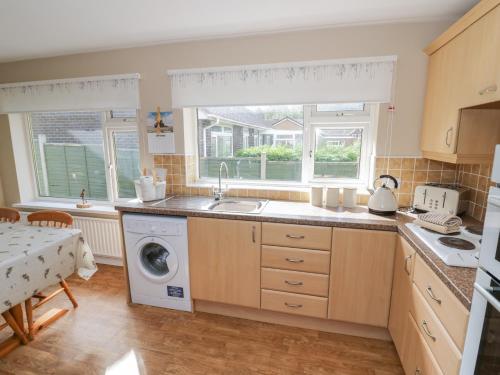 a kitchen with a sink and a washing machine at The Highlands in Church Stretton