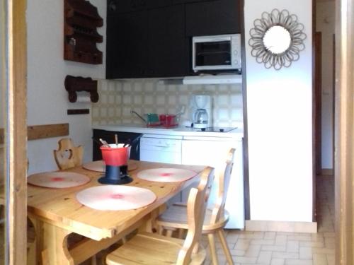 a kitchen with a wooden table with chairs and a kitchen at Appartement Valloire, 2 pièces, 4 personnes - FR-1-263-139 in Valloire