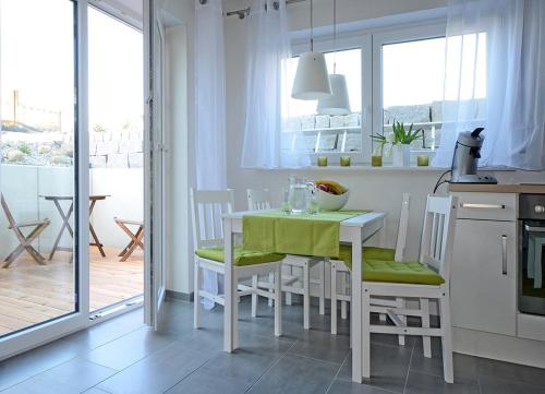 eine Küche mit einem Tisch und Stühlen sowie eine Küche mit einem Balkon in der Unterkunft Ecker in Überlingen