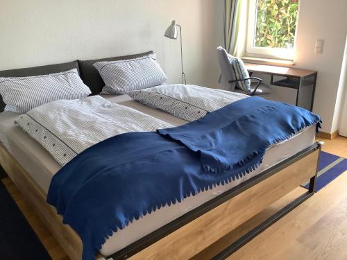 - un lit avec une couverture bleue dans l'établissement Bellevue, à Immenstaad am Bodensee