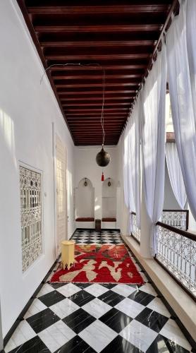 a room with a checkered floor and a ceiling with windows at Riad Tizwa Marrakech in Marrakech