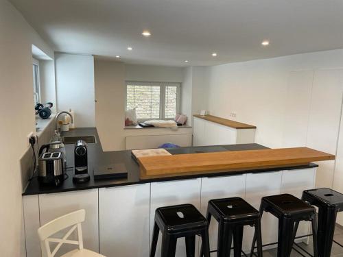 a kitchen with a counter top with four stools at Ferienhaus De Luxe in Engen