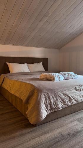 a bedroom with a large bed with a wooden ceiling at Nicolas Resort Club in Kyiv