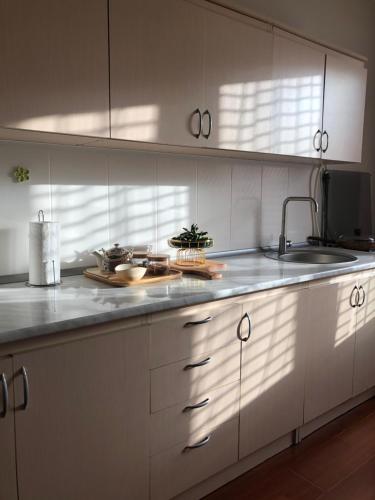a kitchen with white cabinets and a sink at TREFOIL in Lori Berd