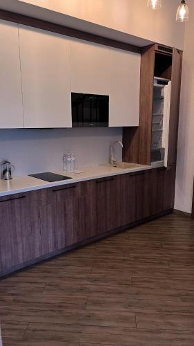 a kitchen with white cabinets and a sink at Nicolas Resort Club in Kyiv