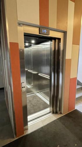 an elevator door in a building with a sign on it at Hugo apartment & parking in Rīga